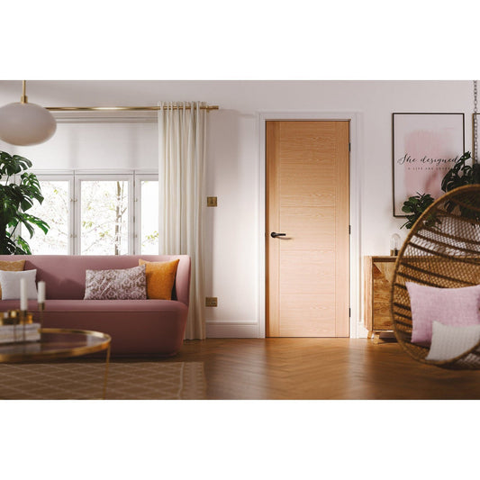  Modern living room interior featuring a light oak wooden door, blush pink sofa, white curtains, indoor plants, and warm natural lighting with contemporary décor.